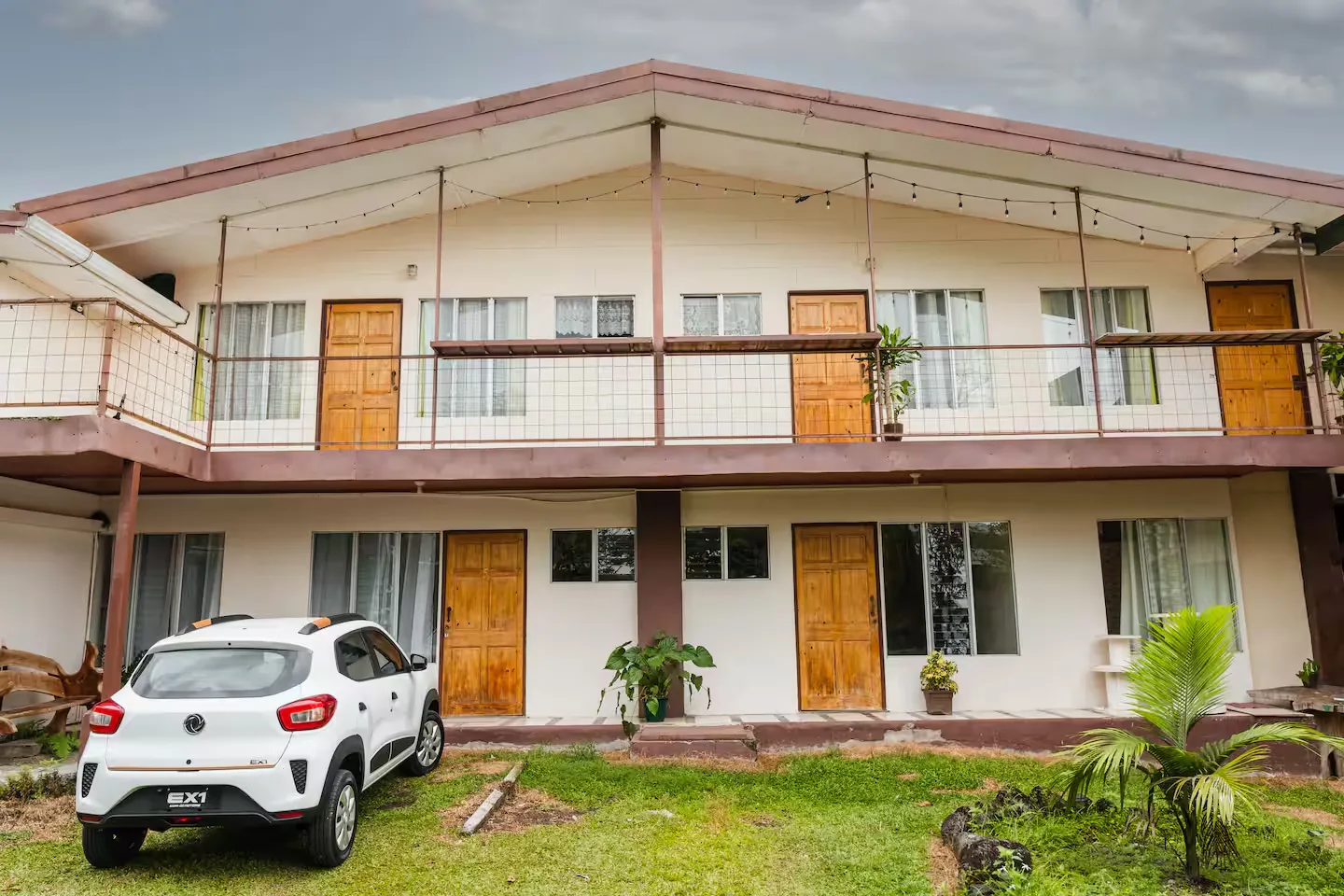 The two-storey building with the five homes, their wooden doors and the lawn