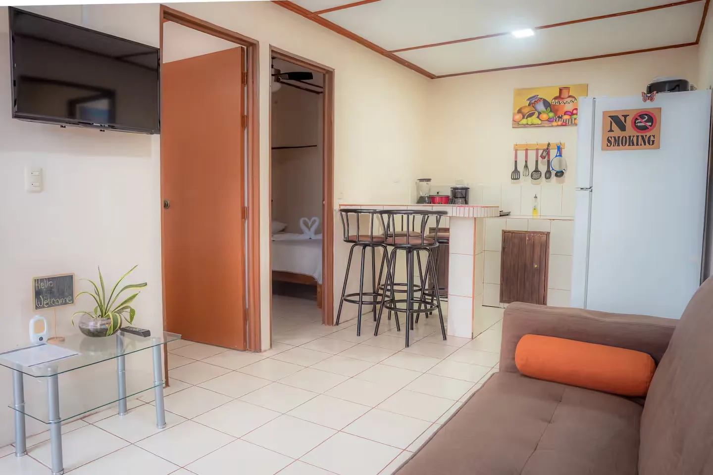 Living room with an open bedroom door and the kitchen counter beyond