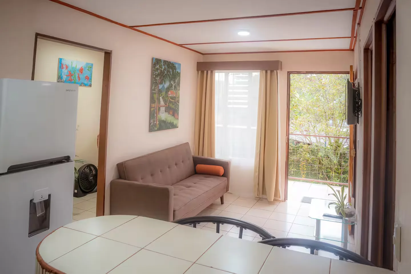 Living room with a sofa and the terrace door open to the garden