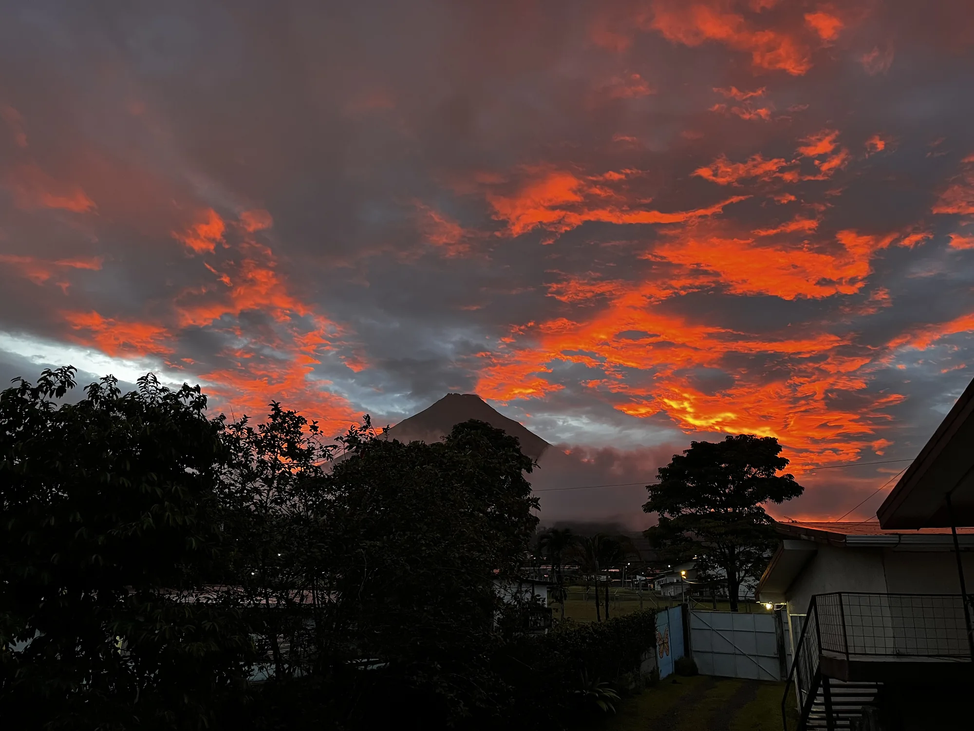 Arenal Volcano silhouetted against a red sunset sky, seen from the property