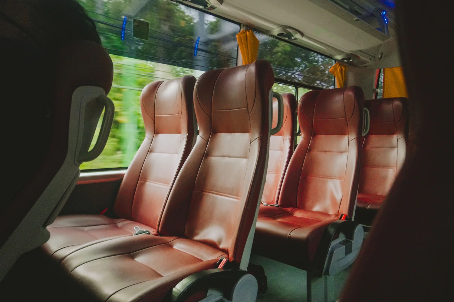 The interior of a shuttle van, with the road blurring past the window